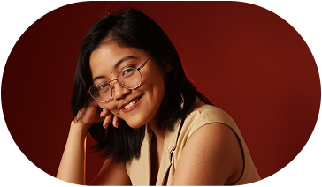 Rheanne, smiling, resting her chin on her hand.